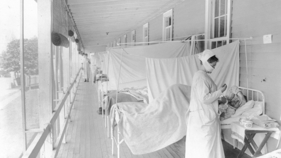 Կոնգրեսի գրադարանի կողմից տրամադրված 1918 թ. նոյեմբերի այս լուսանկարում Վաշինգտոնի Ուոլթեր Ռիդ հիվանդանոցի գրիպի բաժանմունքում բուժքույրը ստուգում է հիվանդի զարկերակը: 1918 թվականին Առաջին աշխարհամարտում զոհվեցին տասնյակ հազարավոր ամերիկացի զինվորներ, իսկ հարյուր հազարավոր ամերիկացիներ մահացան գրիպի համավարակից: 1917 թվականի համեմատ այդ տարի մահվան դեպքերն աճեցին 46 %-ով: Տրամադրել է Harris & Ewing / Կոնգրեսի գրադարանը՝ Associated Press-ի միջոցով: